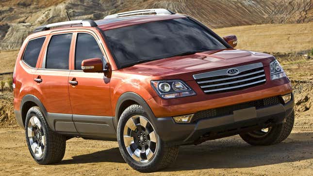 An orange Borrego parked on dirt