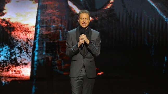 Geoff Keighley stands on stage at his award show. 
