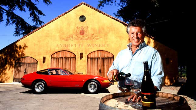 A photo of Mario Andretti pouring wine in front of a Ferrari. 