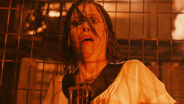 A woman looks horrified inside a cage.