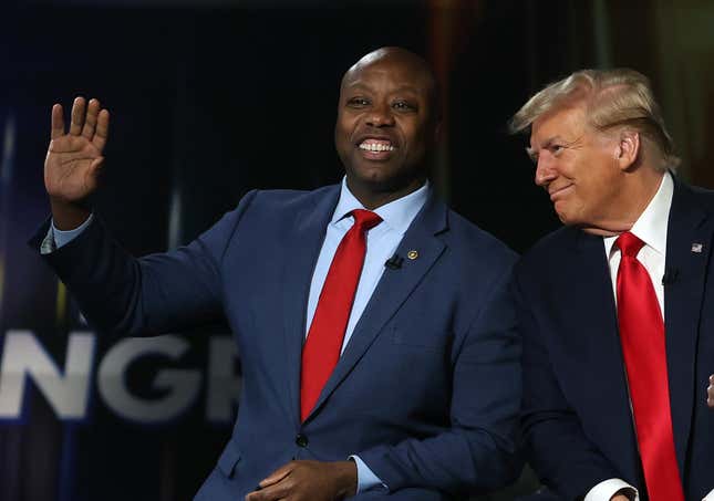 GREENVILLE, SOUTH CAROLINA - FEBRUARY 20: U.S. Sen. Tim Scott (R-SC) waves as he sits with Republican presidential candidate, former U.S. President Donald Trump during a Fox News town hall at the Greenville Convention Center on February 20, 2024 in Greenville, South Carolina.