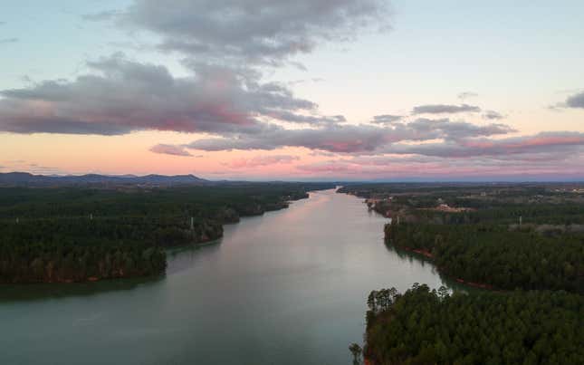 aerial shot of a river in either sunrise or sunset, clouds are in the sky