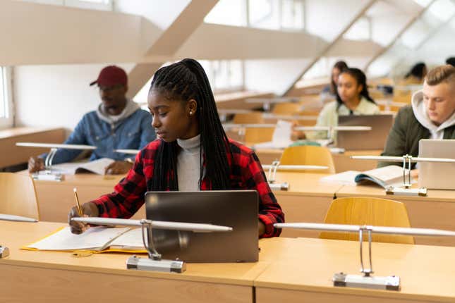 Young African American student writing in classroom