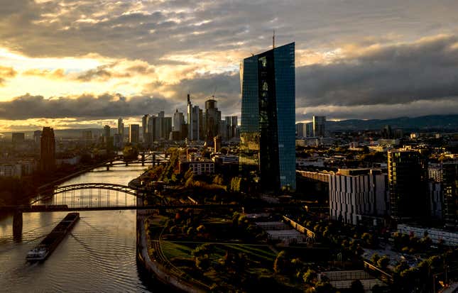 FILE - The sun sets over the buildings of the banking district and the European Central Bank, right, in Frankfurt, Germany, Friday, Oct. 20, 2023. The German government’s panel of independent economic advisers is forecasting that the country&#39;s economy will shrink by 0.4% this year and grow only by a relatively modest 0.7% next year. The panel on Wednesday, Nov. 8, 2023, joined several other forecasters in revising downward its outlook for Europe’s biggest economy. (AP Photo/Michael Probst, File)