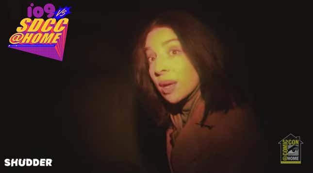 A woman looks at the camera in a dark scene from V/H/S/94.