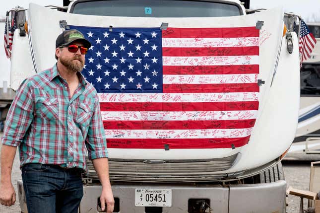 A demonstrator passes an autographed American flag as he prepares to depart Hagerstown Speedway in Hagerstown, Maryland, on March 7, 2022.