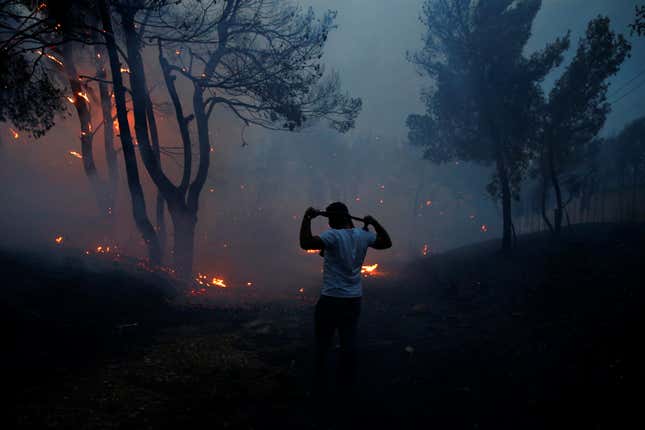 A man uses a cloth to protect himself from smoke in Rafina.