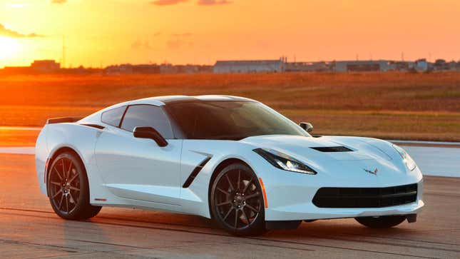 A photo of a white C7 Corvette sports car parked on a runway. 