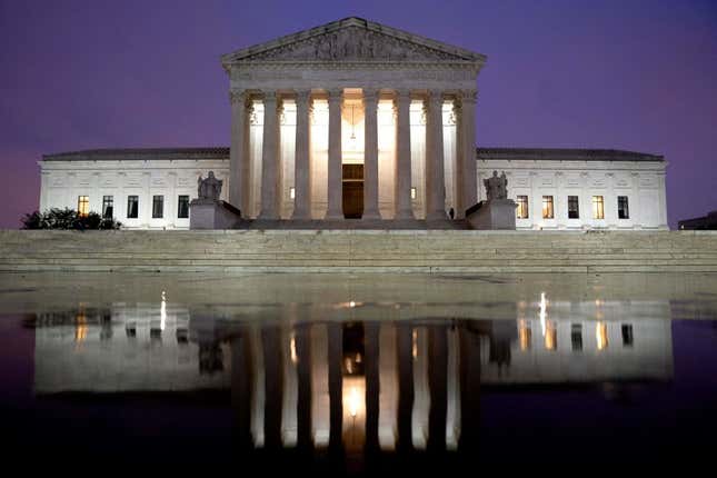 The US Supreme Court is reflected in a puddle of water in Washington, DC, on April 5, 2022