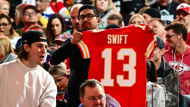 A fan holds up a Kansas City Chiefs jersey with Swift #13 during Super Bowl LVIII Opening Night at Allegiant Stadium in Las Vegas, Nevada on February 5, 2024. The jersey refers to Travis Kelce's girlfriend Taylor Swift.