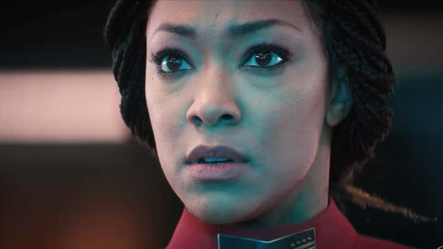 Captain Michael Burnham in Star Trek: Discovery season 4, looking concerned as a computer screen lights her face.