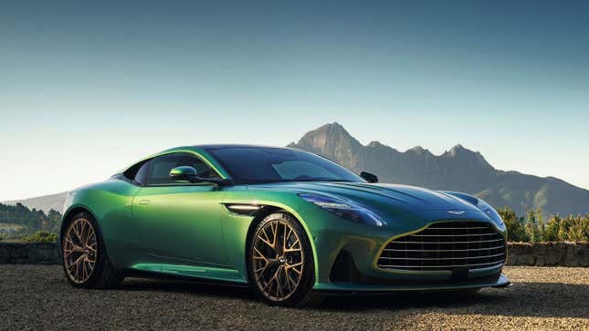 A photo of a green Aston Martin DB12 sports car on a sandy desert scene with mountain backdrop