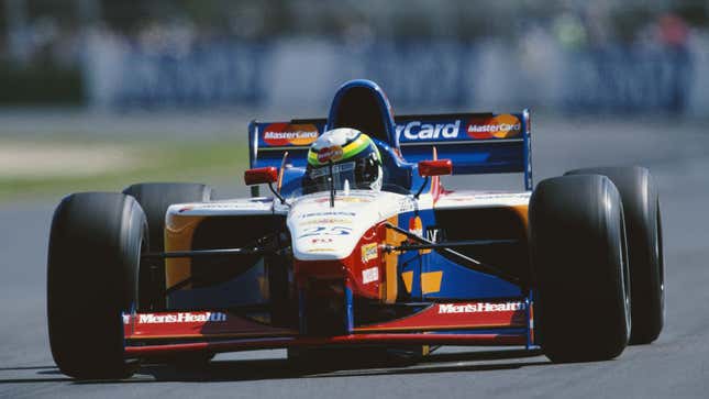 A photo of a red, blue and orange F1 racer. 