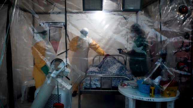 Medical workers check on an Ebola patient in a Biosecure Emergency Care Unit on August 15, 2018 in Beni.