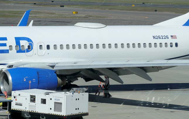 A Medford Jet Center worker walks under a United Boeing 737-824 that landed at Rogue Valley International-Medford Airport from San Francisco with a missing panel Friday, March 15, 2024, in Medford, Ore. (Andy Atkinson/Rogue Valley Times via AP)