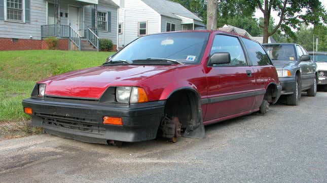 Un Honda Civic 1984-1985 sin ruedas estacionado afuera.