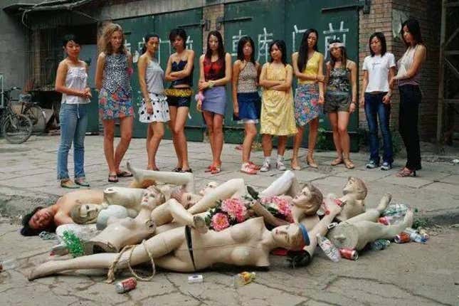 A group of women stare at broken models and a topless man, by Liu Jing.