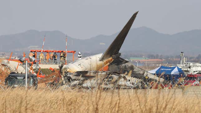 Firefighters and rescue team work at the wreckage of a passenger plane at Muan International Airport on December 29, 2024 in Muan-gun, South Korea. A plane carrying 181 people, Jeju Air Flight 7C2216, crashed at Muan International Airport in South Korea after skidding off the runway and colliding with a wall, resulting in an explosion.