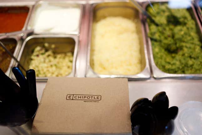 Napkins and utensils sit near guacamole, sour cream, cheese, and salsa at a Chipotle restaurant in Hollywood, California.