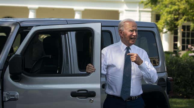 Präsident Joe Biden steht neben der offenen Fahrertür eines silbernen Jeep Wrangler 