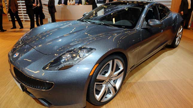 A photo of a dark silver Fisker Karma sports car at an auto show. 