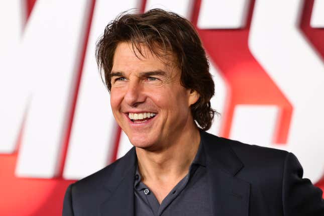 Tom Cruise smiling and looking at a camera not in the frame