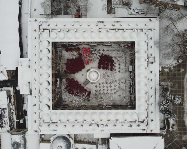 An aerial view of a 15th-century Ottoman-era silk cocoon bazaar and courtyard covered in snow. 