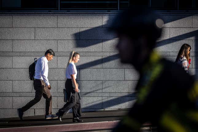 Commuters walk in the early morning summer sun in Auckland, New Zealand, Wednesday, Feb. 14, 2024. New Zealand has entered its second recession in 18 months after the latest round of GDP figures confirmed its economy contracted in the last quarter of 2023. The country&#39;s economy shrank by 0.1% in the quarter to December, and 0.7% in per capita terms, the New Zealand&#39;s official statistics agency, Stats NZ, announced on Thursday, March 21. (Michael Craig/New Zealand Herald via AP)