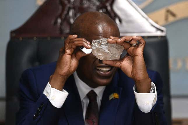 Botswanas Präsident Mokgweetsi Masisi betrachtet am 22. August 2024 in seinem Büro in Gaborone einen großen Diamanten, der in Botswana entdeckt wurde. Der 2.492-Karat-Diamant wurde in der Karowe-Mine der Lucara Diamond Company in Botswana entdeckt.