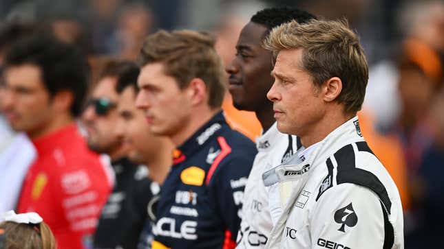 A photo of Brad Pitt and Damson Idris lined up alongside F1 drivers at Silverstone. 