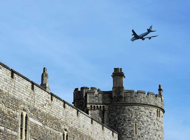 A Cathay Pacific passenger jet flies over Windsor Castle in London.