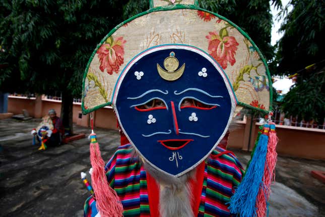 A Tibetan exile dancer sports a traditional face mask.