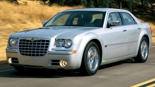 Une Chrysler 300 argentée de 2005 roulant devant de l’herbe sèche