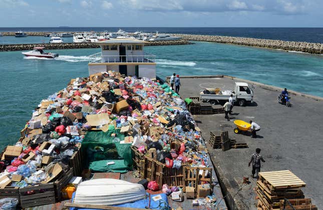 In this September 2013 photo, trash is loaded in Malé onto a boat bound for Thilafushi. 
