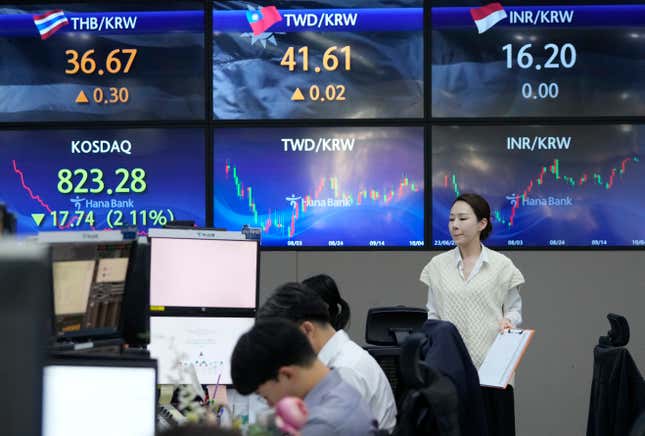 A currency trader passes by the screens showing the foreign exchange rates at the foreign exchange dealing room of the KEB Hana Bank headquarters in Seoul, South Korea, Wednesday, Oct. 4, 2023. Asian markets were sharply lower on Wednesday after Wall Street tumbled as it focused on the downside of a surprisingly strong job market: the likelihood that interest rates will stay high. (AP Photo/Ahn Young-joon)