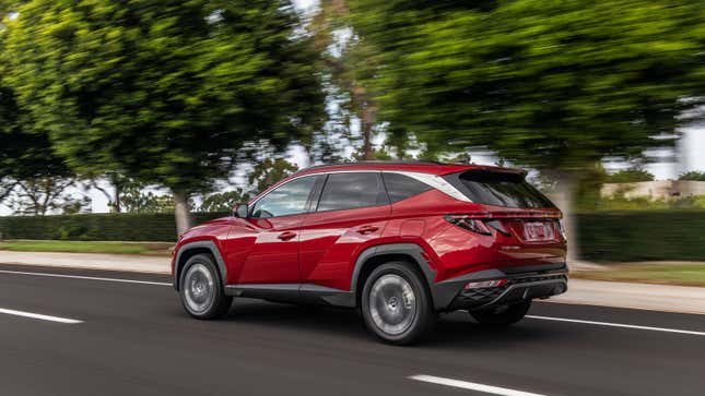 A red Hyundai Tucson SUV on a road. 