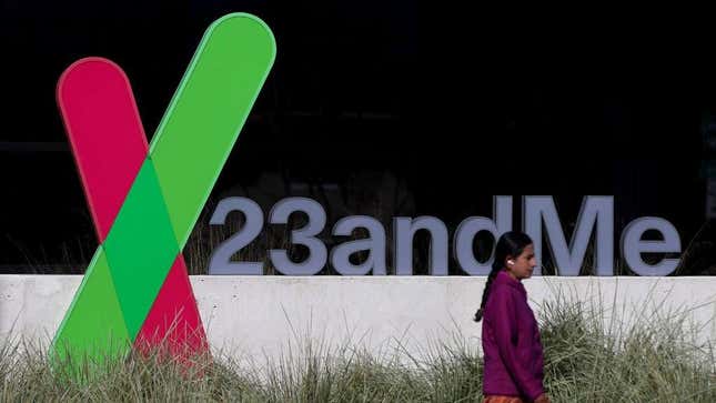 A woman walks in front of a sign outside a 23andMe office.