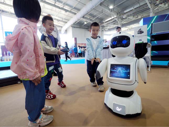 A child watches a humanoid robot dance during the 2024 National Science Popularization Day in Beijing, China. 