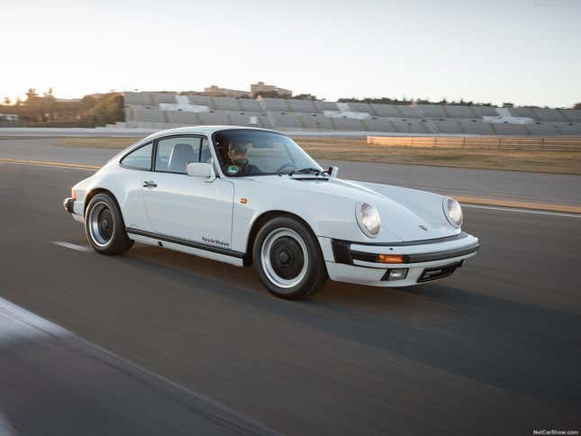 A white Porsche 911 Carrera 3.2 drives on track.