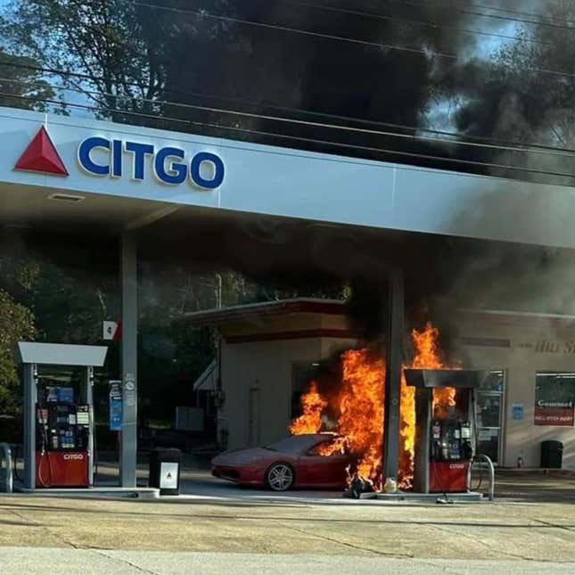 A photo of a Ferrari burning at a gas station. 