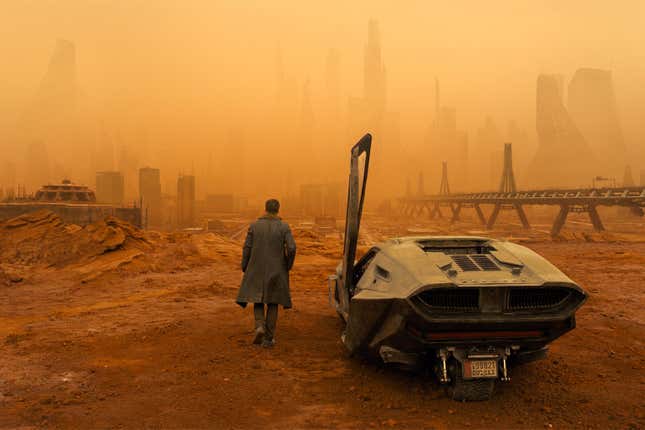 A screenshot from Blade Runner 2049 shows Ryan Gosling walking toward ruins. 