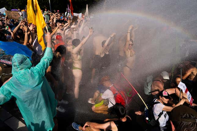 Dutch police uses a water cannon to disperse protestors who blocked a highway during a climate protest of Extinction Rebellion and other activists near the Dutch parliament in The Hague, Netherlands, Saturday, Sept. 9, 2023. (AP Photo/Peter Dejong)