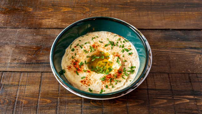 Hummus in bowl on table dressed with olive oil