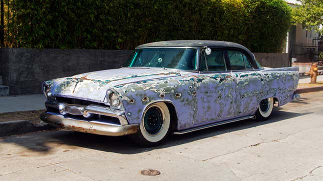 A view of a vintage classic rusty American car in the street