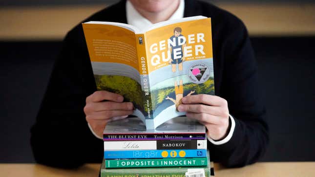 Amanda Darrow, director of youth, family and education programs at the Utah Pride Center, poses with books that have been the subject of complaints from parents on Dec. 16, 2021, in Salt Lake City.