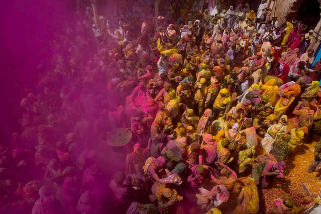 Locals including Hindu widows throw flower petals and colored powder at the Gopinath temple in Vrindavan. (AP Photo /Manish Swarup)