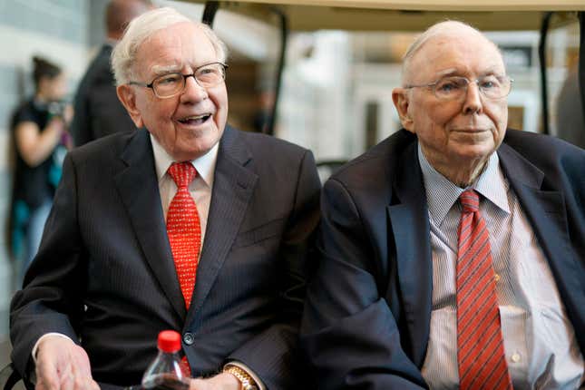 FILE- In this May 3, 2019 file photo, Berkshire Hathaway Chairman and CEO Warren Buffett, left, and Vice Chairman Charlie Munger, briefly chat with reporters before Berkshire Hathaway&#39;s annual shareholders meeting. Buffett credited his longtime partner — the late Charlie Munger — with being the architect of the Berkshire Hathaway conglomerate he’s received the credit for leading and warned shareholders in his annual letter not to listen to Wall Street pundits or financial advisors who urge them to trade often. (AP Photo/Nati Harnik, File)