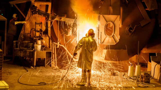 A worker cleans a big melting pot at the Salzgitter AG steelworks.