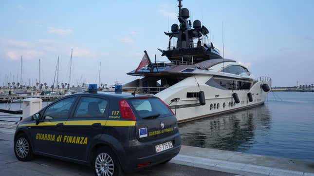 An Italian Finance Police car is parked in front of the yacht “Lady M”, owned by Russian oligarch Alexei Mordashov, docked at Imperia’s harbor, on March 5, 2022. (Photo by Andrea BERNARDI / AFP)