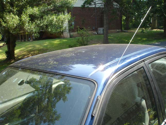 A photo of an older car's metal antenna 